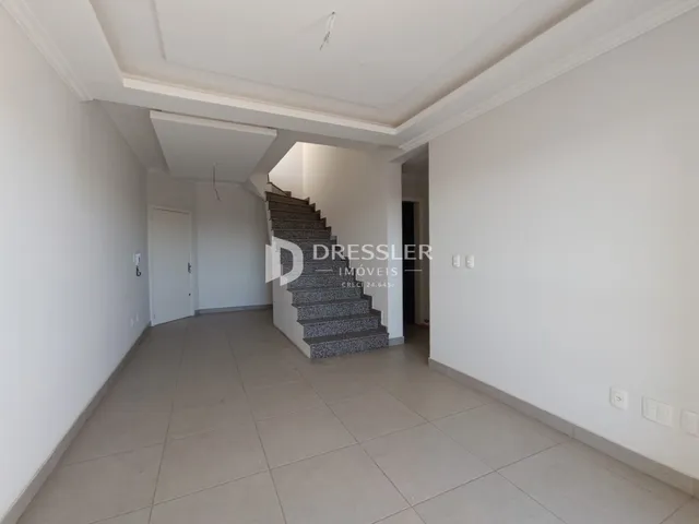 Corredor interno com escadaria e piso claro.