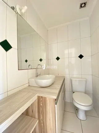 Foto de um banheiro com revestimento de azulejos brancos e bancada.