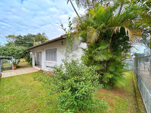 Fachada de uma casa em Lajeado, Brasil, com jardim exuberante e vegetação densa.