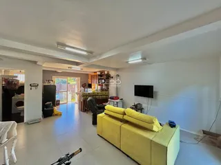 Sala de estar ampla com piso de cerâmica clara e sofá amarelo grande.