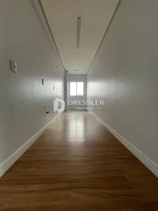 Corredor interno com piso de madeira em uma residência.