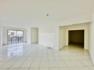 Ambiente interno de uma sala ampla com piso de cerâmica branca.