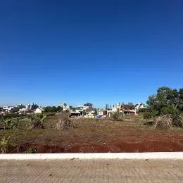 Vista panorâmica de uma paisagem seca com vegetação rasteira sob um céu azul claro.