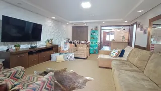 Sala de estar com sofá e televisão em um apartamento.
