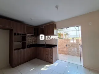 Cozinha com armários de madeira e piso claro.