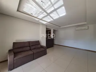 Sala de estar com sofá e piso de cerâmica clara.