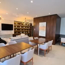 Sala de estar com painel de madeira e televisão na parede.