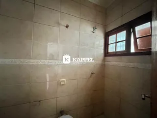 Parede revestida com azulejos claros em um ambiente interno.