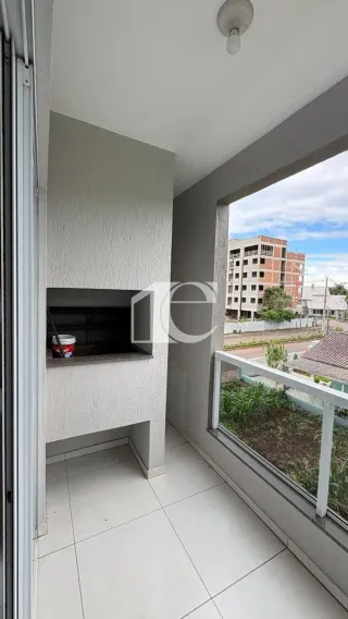 Vista de um interior com parede branca e janela de grande abertura.