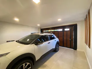 Interior de uma sala com piso de cerâmica e um veículo estacionado.