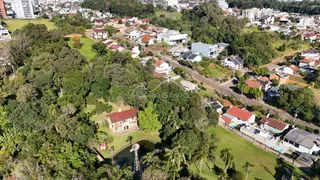 Vista aérea de uma área residencial com casas e vegetação.