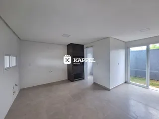 Esta é uma sala ampla e vazia com piso claro e uma parede de destaque em pedra escura.