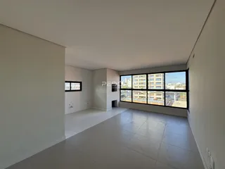 Ambiente interno de um apartamento em Lajeado, Brasil, com grande janela voltada para a cidade.