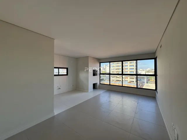 Ambiente interno de um apartamento em Lajeado, Brasil, com grande janela voltada para a cidade.