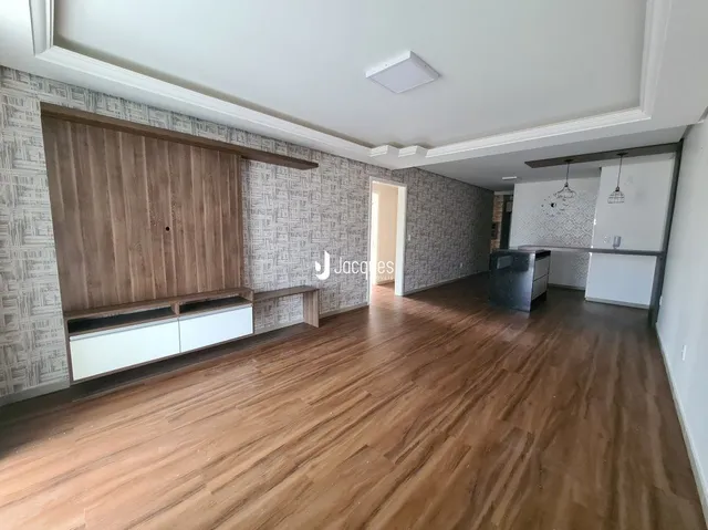 Vista interna de uma sala com piso de madeira clara.