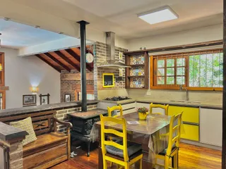 Sala de jantar e cozinha com detalhes em tijolo e madeira.