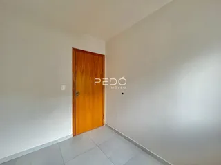 Vista de um corredor interno com porta de madeira em uma residência.