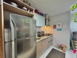 Foto da cozinha com geladeira inox e armários de madeira.