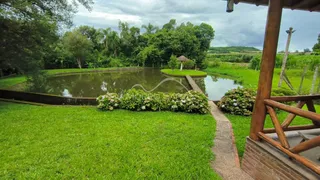 Vista externa de um jardim com gramado verde e um lago.
