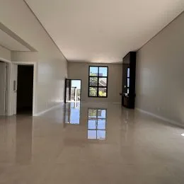 Corredor interno com piso claro e janelas ao fundo.