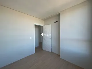 Hall de entrada com piso de madeira clara.