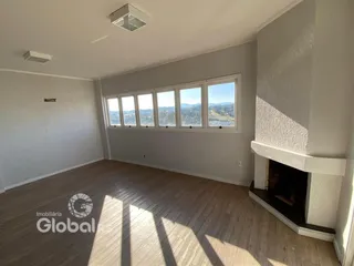 Sala de estar com vista para a paisagem através de grandes janelas.