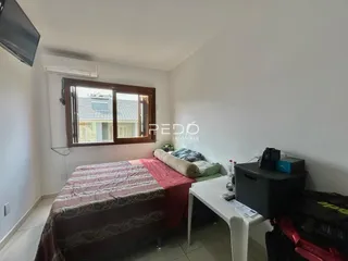 Quarto com janela de madeira e cama no interior de uma residência.