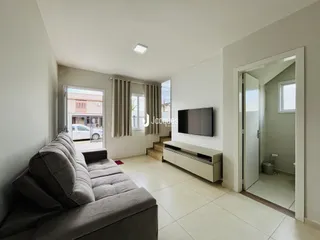 Sala de estar com sofá e piso de cerâmica em um imóvel no Brasil.