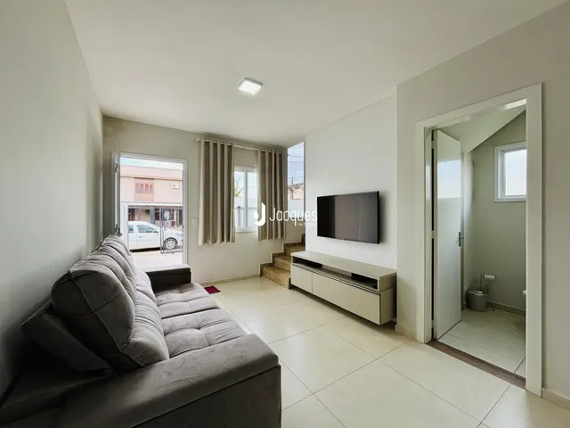 Sala de estar com sofá e piso de cerâmica em um imóvel no Brasil.