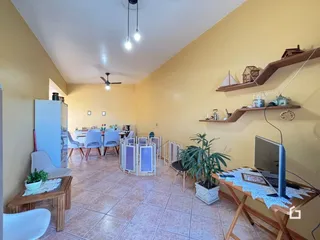Ambiente interno de uma sala de jantar com piso de cerâmica e móveis de madeira.