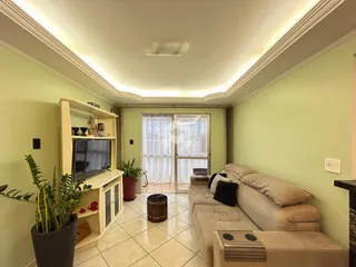 Sala de estar com sofá e móveis em um apartamento.