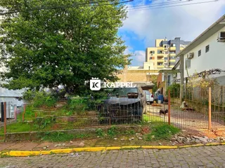 Vista externa de uma propriedade com vegetação e cerca.
