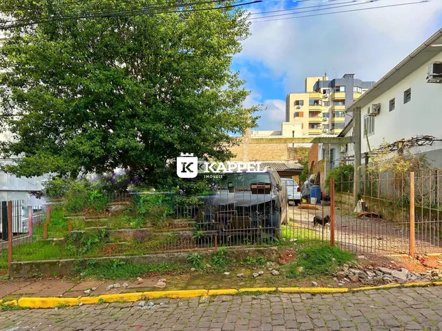 Vista externa de uma propriedade com vegetação e cerca.