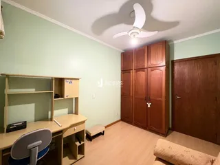 Quarto com armários em madeira e piso de madeira clara.