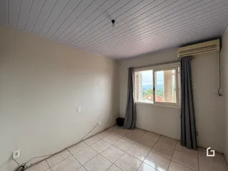 Ambiente interno de uma sala com piso de cerâmica e teto de painéis em Lajeado.