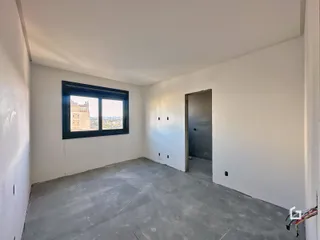 Ambiente interno de uma sala com vista para a cidade.