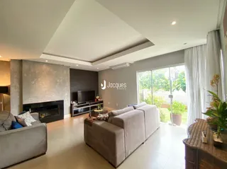 Sala de estar moderna com lareira e grandes janelas.