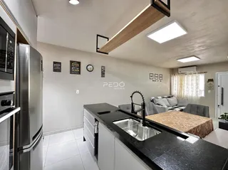Imagem de uma cozinha e sala de estar moderna em um imóvel no Brasil.