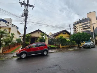 Foto de uma rua residencial em Lajeado, Brasil, com um carro vermelho estacionado.