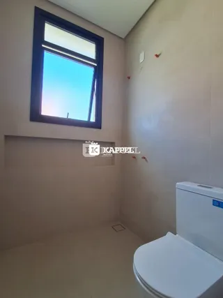 Foto de um banheiro mostrando uma janela com vista para o céu azul.