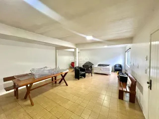 Sala de estar ampla com piso de cerâmica e móveis de madeira.