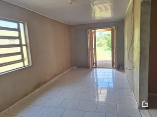 Corredor interno com piso de cerâmica e porta de acesso ao exterior.