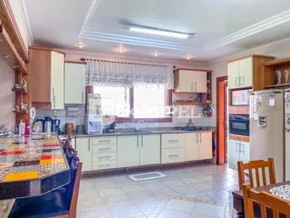 Foto interna de uma cozinha com armários claros e piso de cerâmica.
