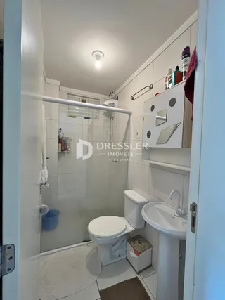 Foto de um banheiro interno com revestimento cerâmico branco.