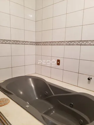 Foto de um banheiro com banheira e azulejos brancos.
