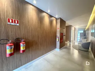 Hall de entrada com paredes de madeira e piso claro.