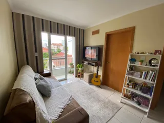 Sala de estar com sofá e porta de madeira em um imóvel.