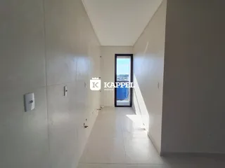 Corredor interno de um imóvel com piso claro e vista na extremidade.
