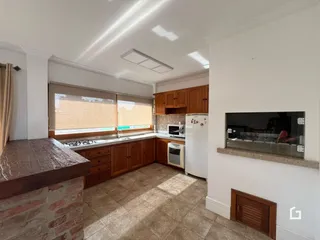 Foto da cozinha com armários de madeira e piso de cerâmica.