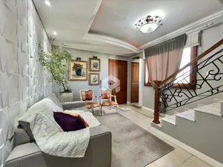 Sala de estar com sofá e escadaria em um imóvel.